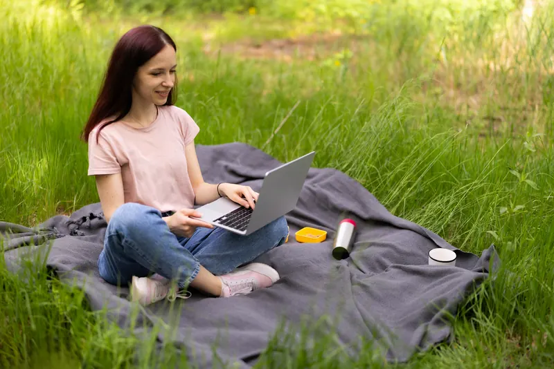 Persona trabajando con laptop en el campo